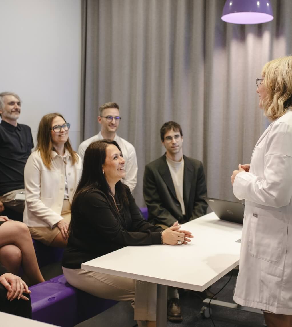 A person standing and presenting to a group during a meeting